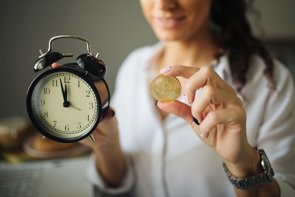 A physical bitcoin coin rests beside financial charts representing digital asset markets.