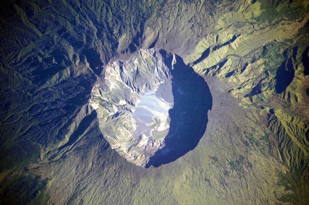 Faster Ash Cloud Modelling Helps Airlines Reroute Safely volcano erupting with an ash cloud over an island